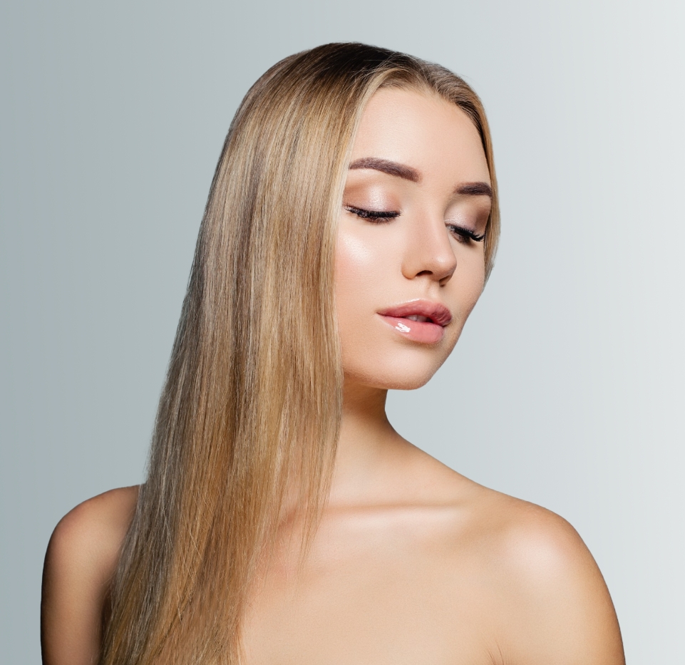 Beautiful woman with long, straight hair smiling softly after Medspa treatment in Beverly Hills, showcasing radiant skin and natural beauty.