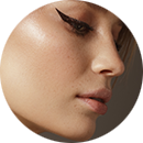 Close-up side profile of a woman with smooth skin and winged eyeliner after buccal fat removal in Newport Beach.