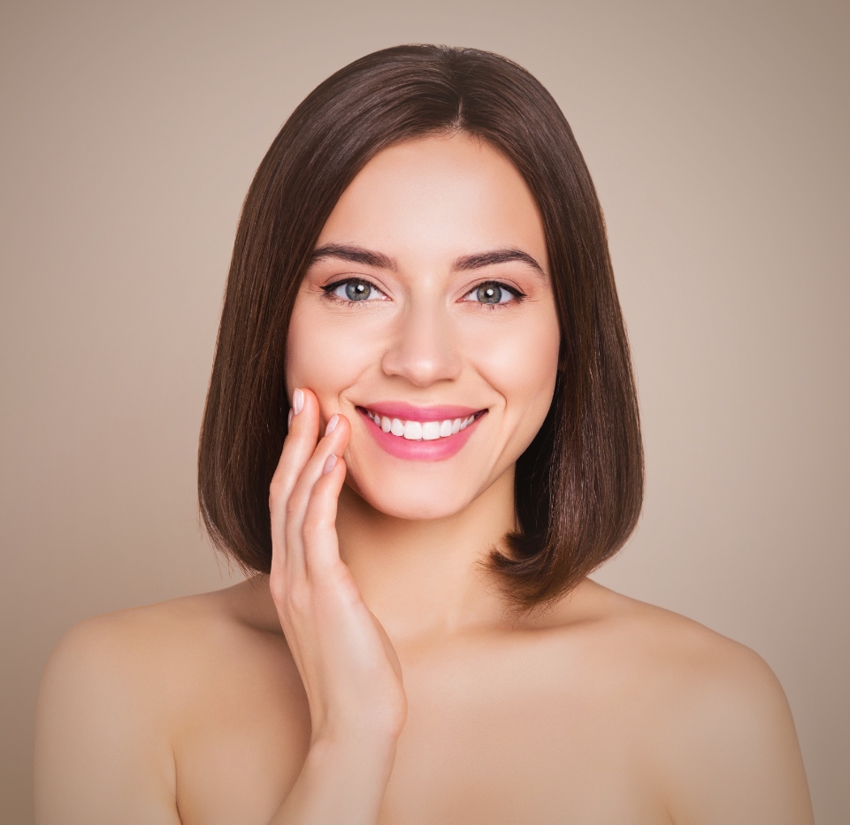 Smiling woman with clear, youthful skin after facial plastic surgery in Newport Beach, radiating confidence and natural beauty.