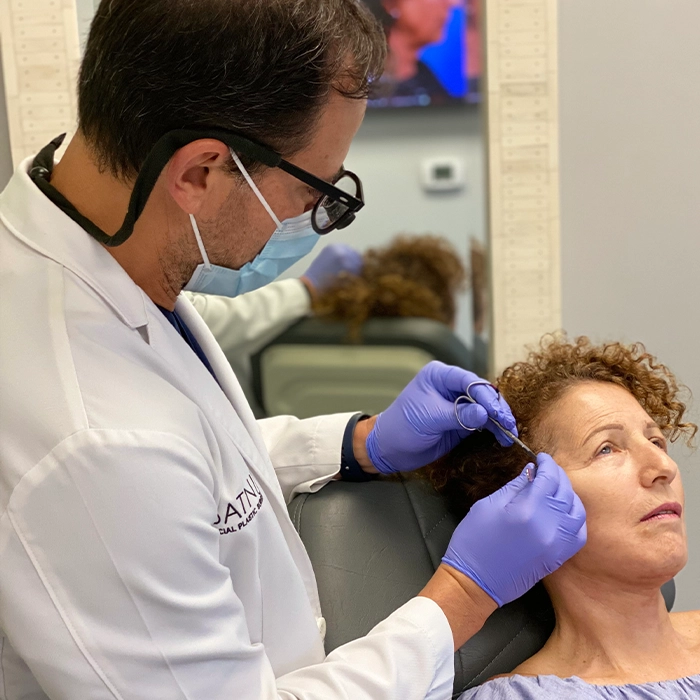 Dr. Batniji performing a mini facelift procedure on a woman in his Newport Beach and Beverly Hills office, showcasing expertise in facial rejuvenation treatments.